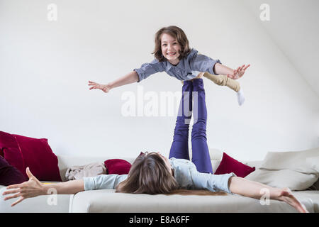 Mother balancing her daughter on her feet Stock Photo