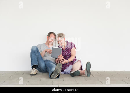Mature couple using digital tablet, smiling Stock Photo