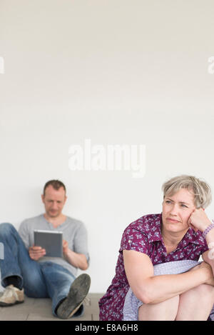 Mature woman looking away  while mature man using digital tablet in background Stock Photo