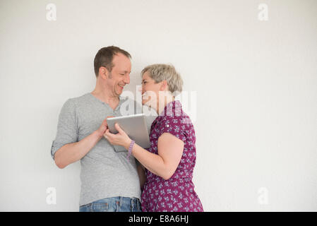 Mature couple using digital tablet, smiling Stock Photo