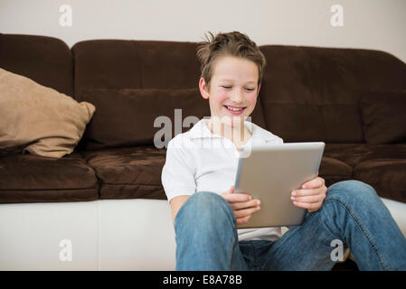 Boy in living room using digital tablet Stock Photo