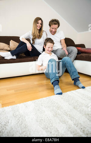 Happy family in living room with digital tablet Stock Photo