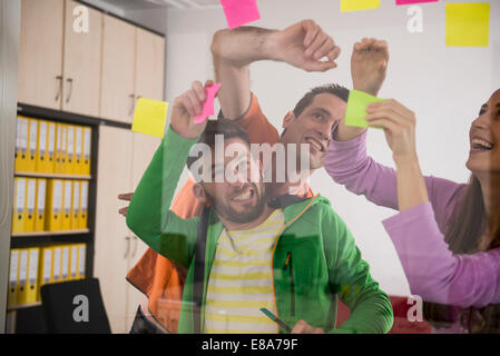work colleagues arguing deciding using post-ist Stock Photo