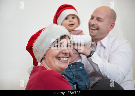 Family celebrating christmas with christmas caps Stock Photo