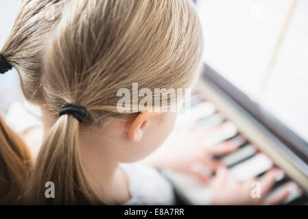 Young girl 6 years old practicing playing piano Stock Photo