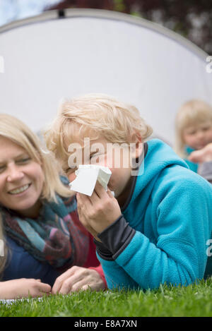 Family in garden young boy with hayfever tissue Stock Photo