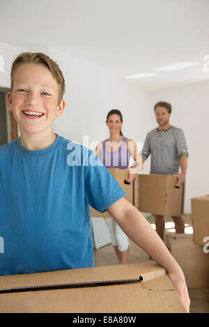 Family father mother son carrying boxes moving in Stock Photo