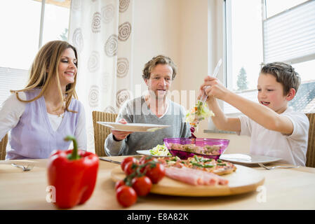 Family eating pizza and salad at home Stock Photo