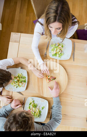 Family fighting for last slice of pizza Stock Photo