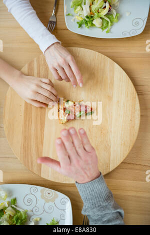 Family fighting for last slice of pizza Stock Photo