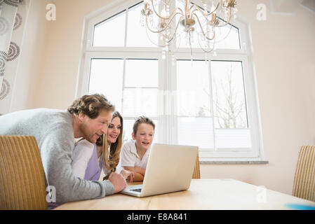 Family using laptop at home Stock Photo