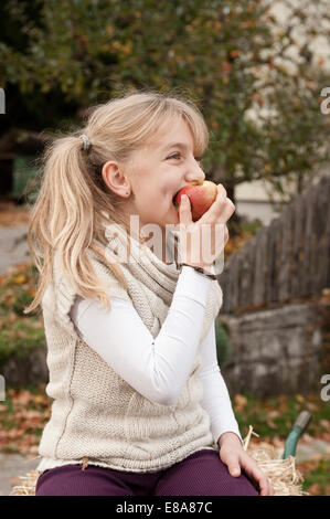 Blond girl eating an apple Stock Photo