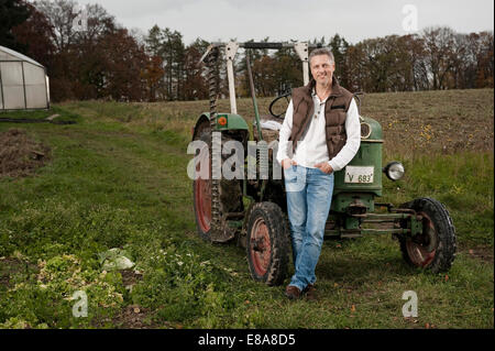 Man leaning against tractor Stock Photo