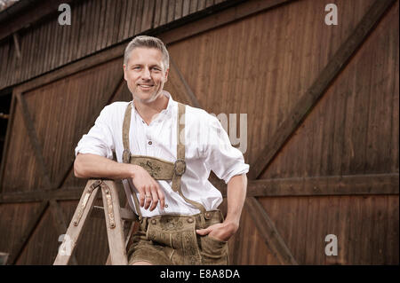 Man in lederhosen on farm, Barvaria, Germany Stock Photo