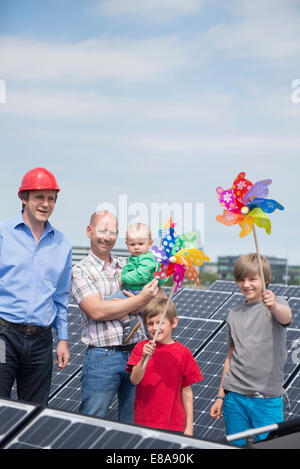 Two men father kids toy windmill solar park Stock Photo