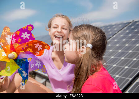 Two girls solar panel toy windmill Stock Photo