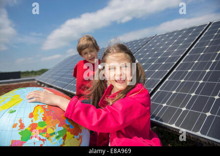 Portrait two kids globe balloon solar panel Stock Photo