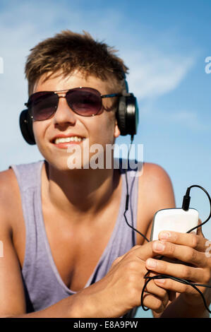 Portrait of teenage boy hearing music at beach, Koh Lipe, Thailand
