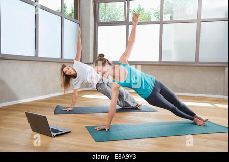 Two women Yoga training fitness studio laptop Stock Photo