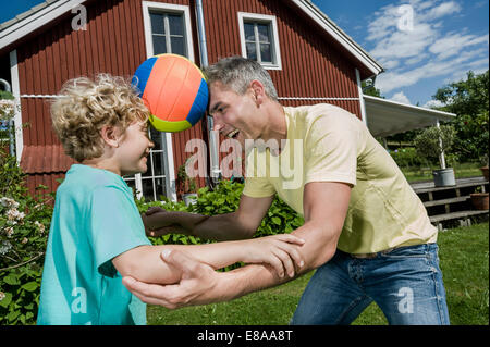 Father son balancing football playing fun garden Stock Photo