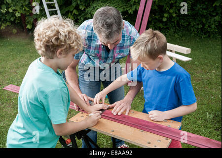 Father sons working garden building wood Stock Photo