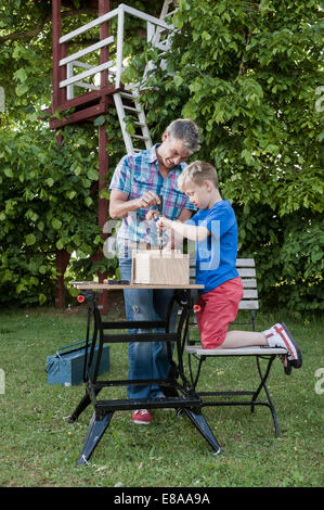 Building birdhouse father son together working Stock Photo