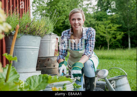 Young woman working in garden smiling Stock Photo