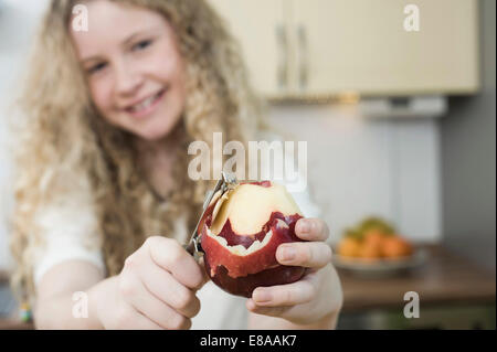 Girl in kitchen peeling apple Stock Photo