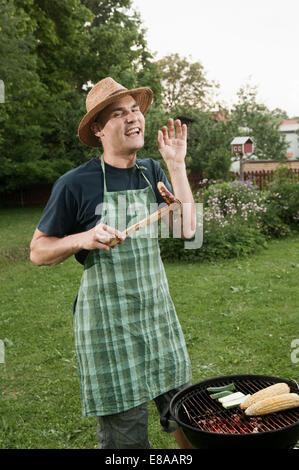 Man grill barbecue garden cooking sausage Stock Photo