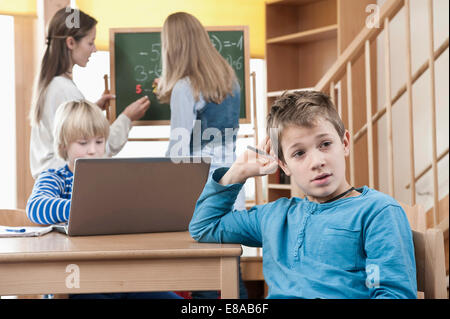 Female childcare assistant helping children by doing homework Stock Photo