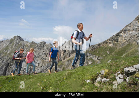 Father teenage kids hiking in mountains Alps Stock Photo