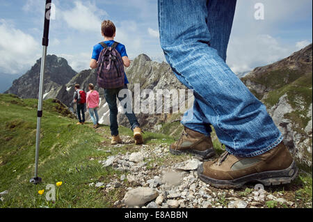 Father teenage kids hiking in mountains Alps Stock Photo