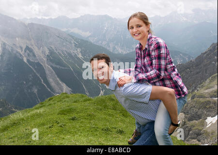 Father carrying young girl on back Alps Stock Photo