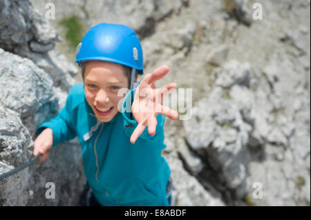 Teenager climbing Alps mountains reaching helping Stock Photo