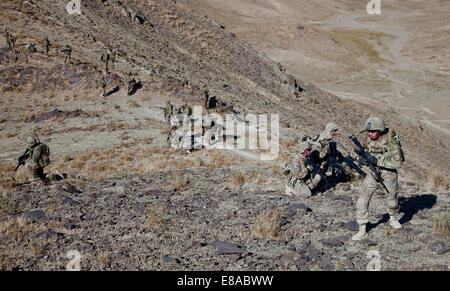 U.S. Soldiers with Bandit Troop, 1st Squadron, 3rd Cavalry Regiment and Afghan National Army soldiers climb to the top of a mountain for a re-enlistment ceremony for two Soldiers in Paktia province, Afghanistan, Sept. 21, 2014. Stock Photo