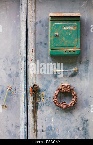Green a mailbox and Iron Door knocker on the old wooden doors Stock Photo