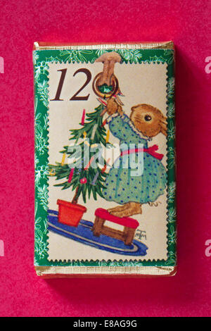 Count down to Christmas with individual advent chocolate bars isolated on red background - calendar day 12 of set of 24 Stock Photo