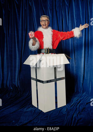 Santa in box with Christmas gift Stock Photo