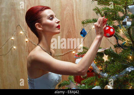 Woman decorating Christmas tree Stock Photo