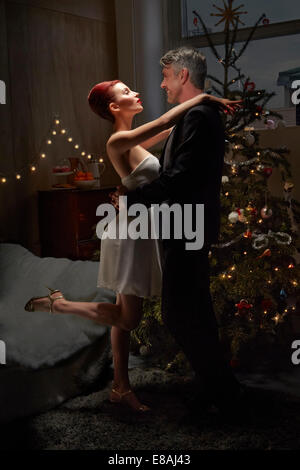 Husband and wife dancing by Christmas tree Stock Photo