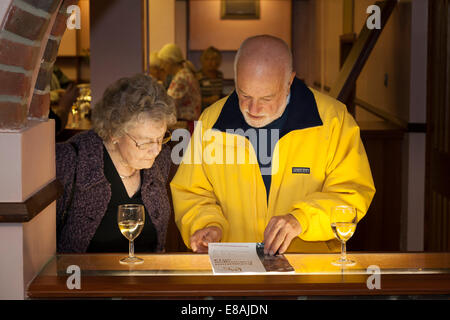 Guests view the catalogue at the Petersfield Arts and Crafts 2014 Exhibition preview evening. Stock Photo