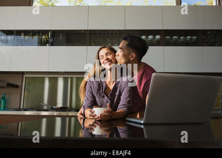 Loved up couple in dining room drinking coffee Stock Photo