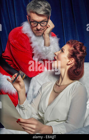 Woman showing Christmas list to Santa Stock Photo