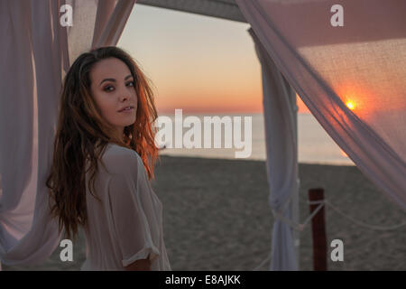 Portrait of young woman under beach gazebo, Castiadas, Sardinia, Italy Stock Photo