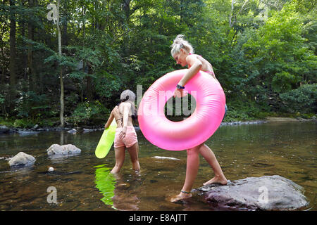 Women in river with inflatable rings Stock Photo