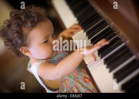 Cute baby girl playing piano Stock Photo