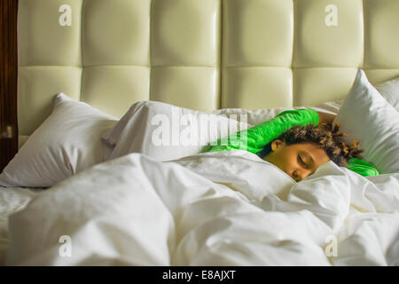 Boy lying asleep in bed Stock Photo