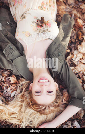 Woman lying on autumn leaves Stock Photo