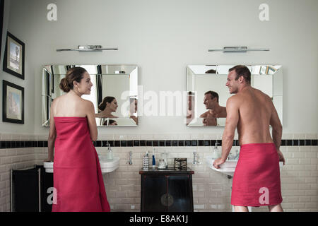 Young couple at sinks in his and hers bathroom Stock Photo