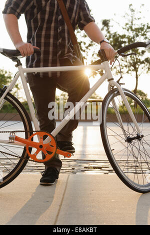 Neck down view of male cycle messenger taking a break